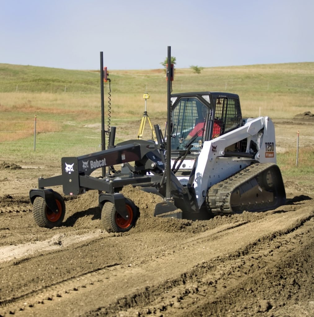 Land grading and leveling equipment in operation